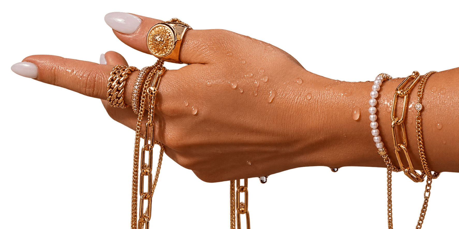 A hand wearing gold rings, chains and bracelets, wet with meltwater