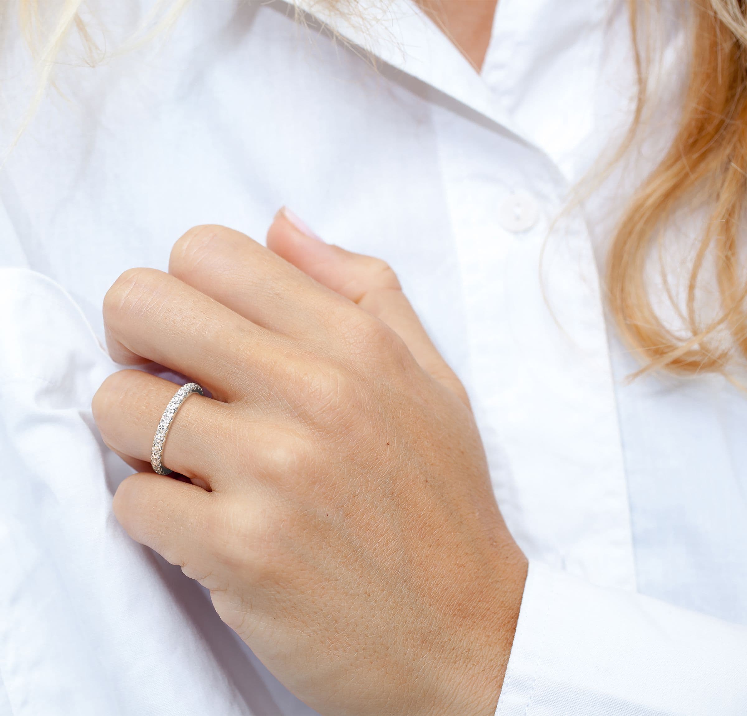 A hand wearing a handmade pavé diamond band